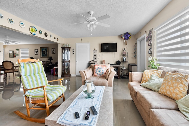 living room with ceiling fan and a textured ceiling