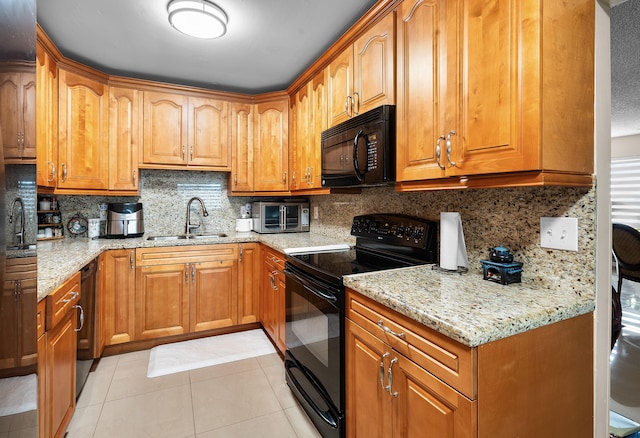 kitchen featuring light stone counters, sink, black appliances, and light tile patterned flooring