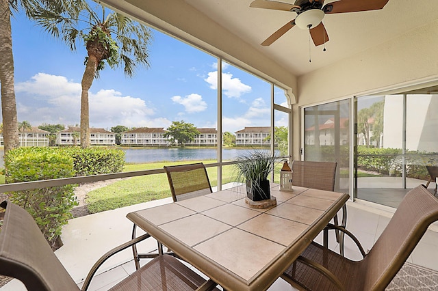 sunroom / solarium featuring a water view and ceiling fan