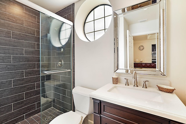 bathroom with vanity, toilet, and a shower with door