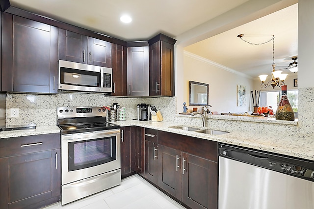 kitchen with light stone countertops, decorative backsplash, stainless steel appliances, and sink