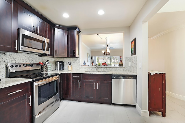 kitchen featuring light stone countertops, appliances with stainless steel finishes, sink, and backsplash