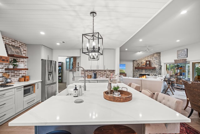 kitchen with stainless steel appliances, a kitchen breakfast bar, and a large island with sink