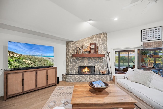 living room with lofted ceiling, a fireplace, and light hardwood / wood-style floors