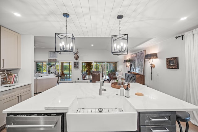 kitchen featuring an inviting chandelier, sink, decorative light fixtures, and an island with sink