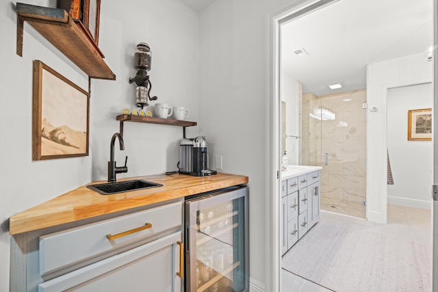 bar with butcher block counters, sink, light tile patterned floors, and wine cooler