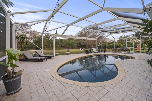 view of swimming pool with a lanai and a patio area