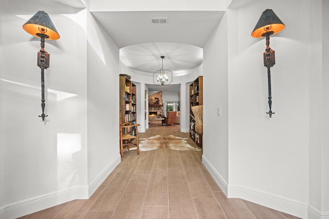 hall featuring a chandelier and light wood-type flooring