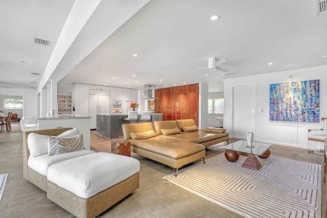 living room featuring plenty of natural light and ceiling fan