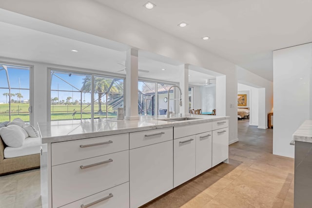 kitchen with ceiling fan, a healthy amount of sunlight, sink, and white cabinets