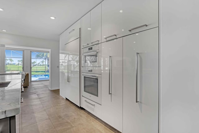 kitchen featuring white cabinetry and light stone countertops