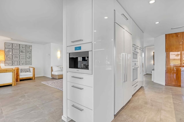 kitchen featuring oven, white oven, and white cabinets