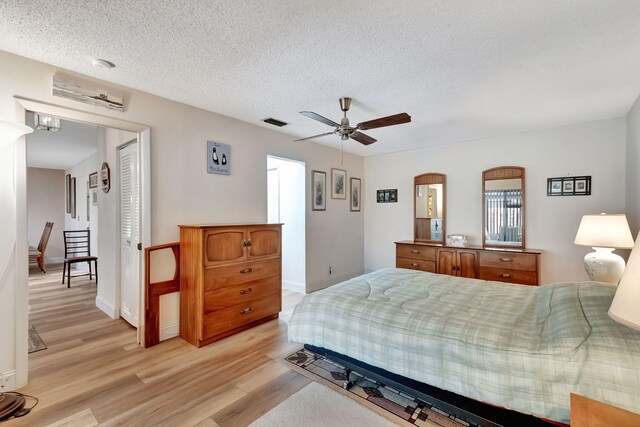 bedroom featuring ceiling fan, a textured ceiling, and light hardwood / wood-style flooring