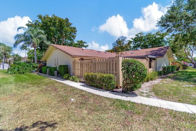 exterior space featuring stucco siding, a front yard, and fence