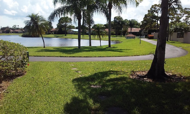 view of community with a lawn and a water view