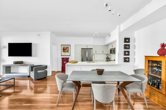 dining space with sink and light wood-type flooring