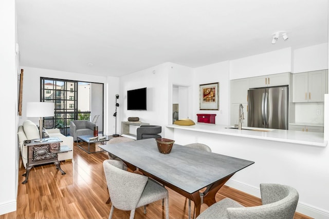 dining space featuring sink and light wood-type flooring