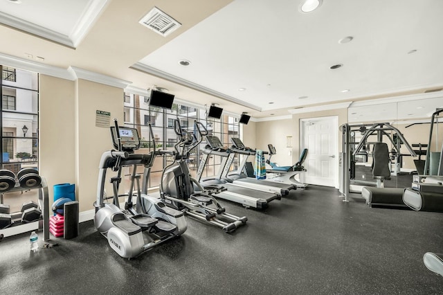 gym featuring a tray ceiling and crown molding