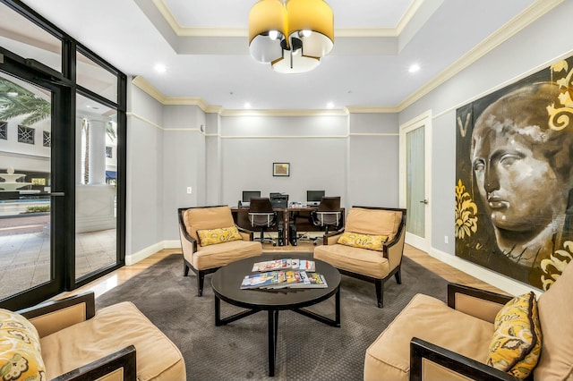 living area with hardwood / wood-style flooring, ornamental molding, and a tray ceiling