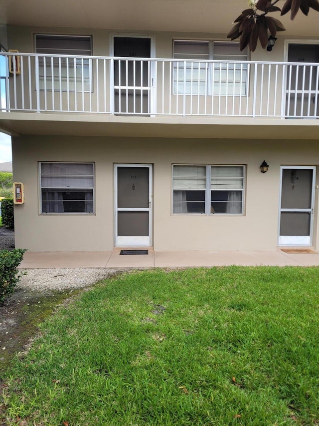 property entrance featuring a yard, ceiling fan, and a patio area