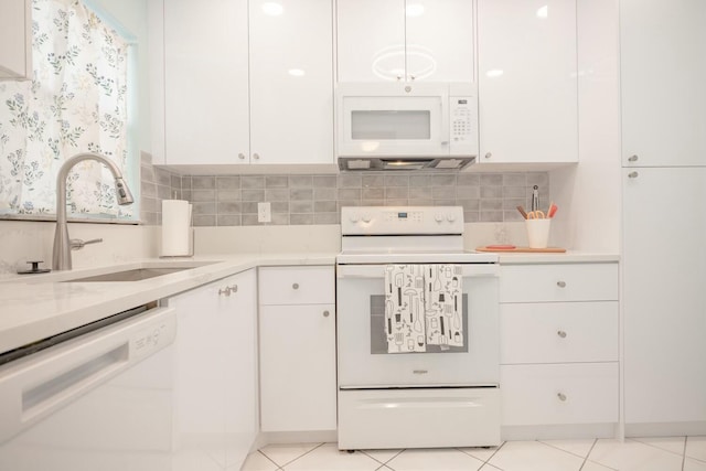 kitchen featuring sink, tasteful backsplash, light tile patterned floors, white appliances, and white cabinets