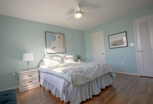 bedroom with dark hardwood / wood-style flooring and ceiling fan