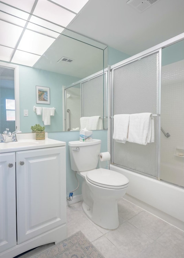 full bathroom featuring vanity, combined bath / shower with glass door, tile patterned floors, and toilet