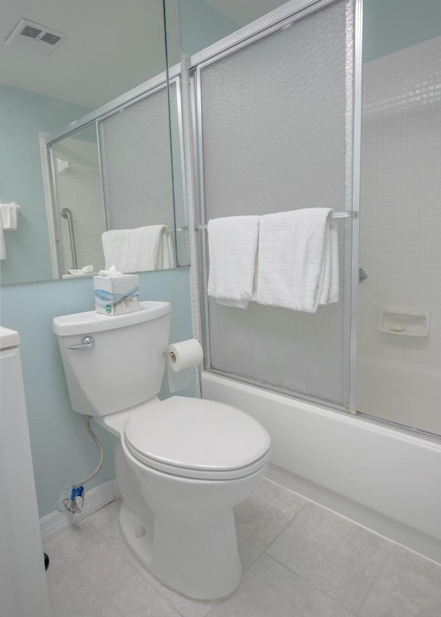 bathroom with tile patterned floors, shower / bath combination with glass door, and toilet