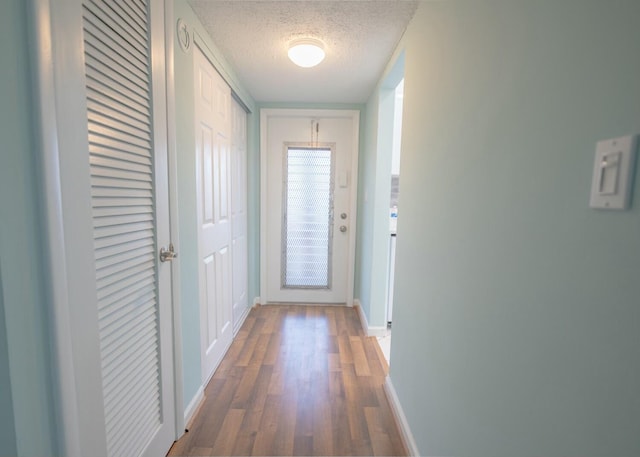 corridor with dark wood-type flooring and a textured ceiling