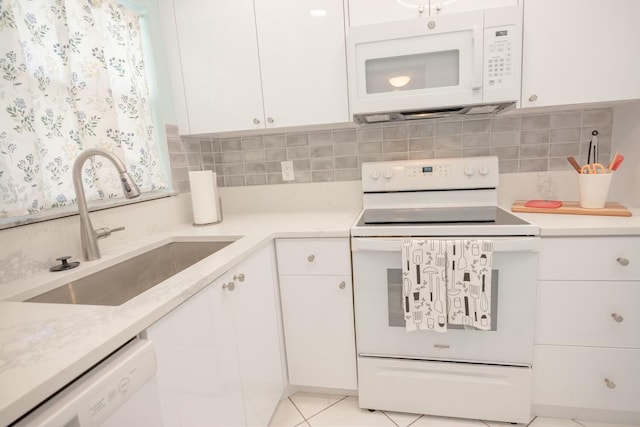 kitchen featuring sink, backsplash, white cabinets, and white appliances