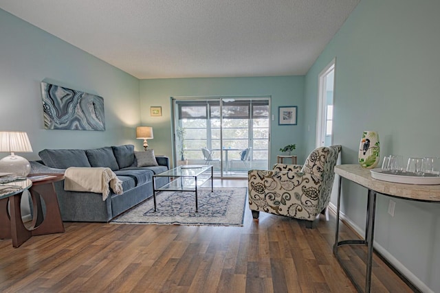 living room with dark wood-type flooring and a textured ceiling