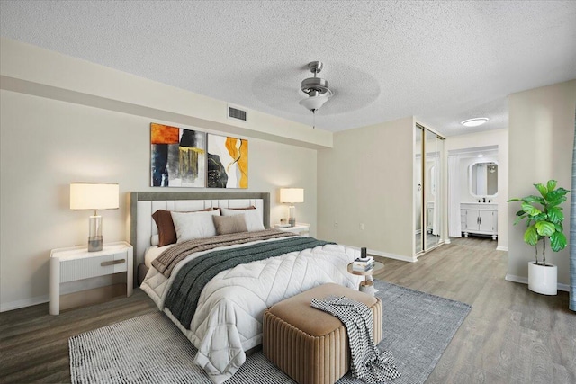 bedroom with ceiling fan, hardwood / wood-style flooring, and a textured ceiling