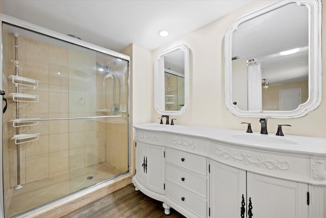 bathroom featuring an enclosed shower, vanity, and wood-type flooring