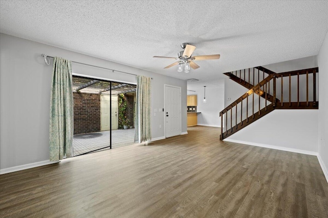 unfurnished living room featuring hardwood / wood-style flooring, ceiling fan, and a textured ceiling