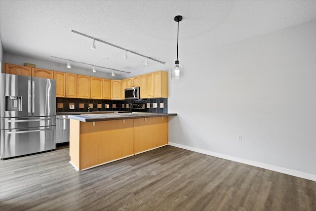 kitchen featuring tasteful backsplash, a breakfast bar area, hanging light fixtures, kitchen peninsula, and stainless steel appliances