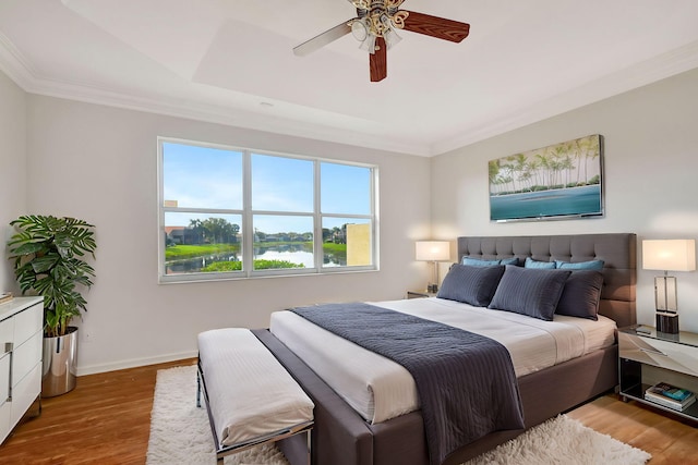 bedroom featuring baseboards, a ceiling fan, crown molding, and light wood-type flooring