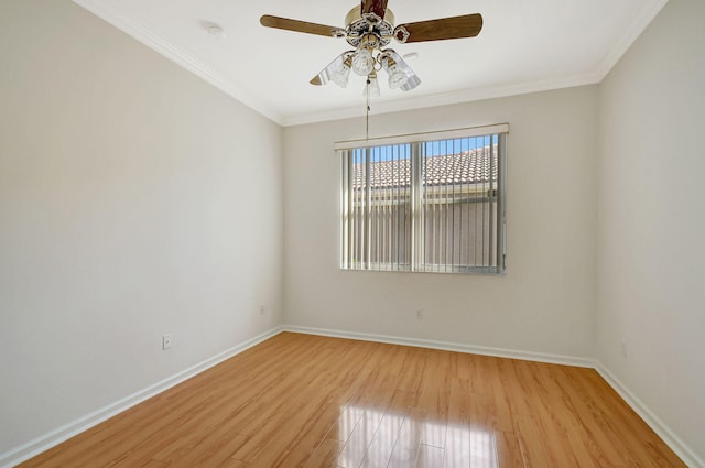 spare room with crown molding, baseboards, ceiling fan, and light wood-type flooring