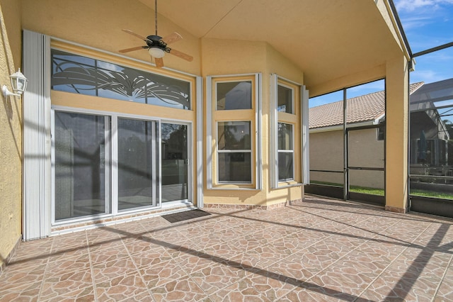 view of patio with ceiling fan and glass enclosure