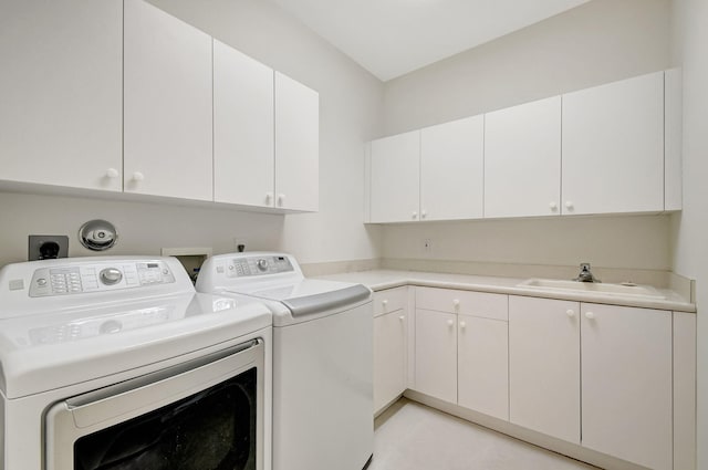 laundry area featuring washer and clothes dryer, cabinet space, and a sink