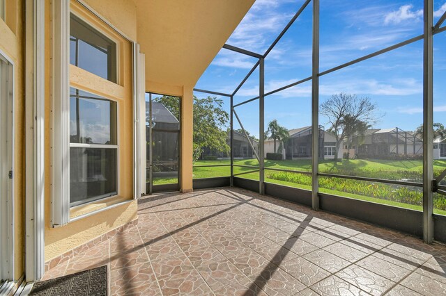 rear view of property with a lanai, a lawn, and ceiling fan