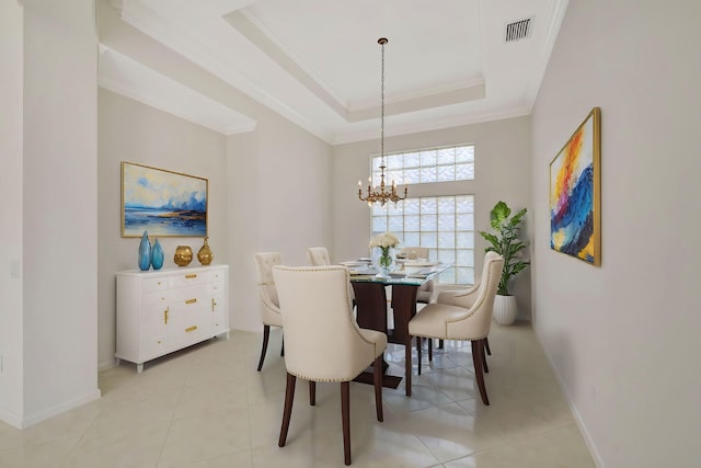 tiled dining room featuring ornamental molding, a notable chandelier, and a tray ceiling