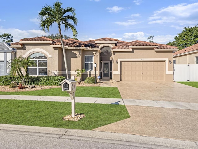 mediterranean / spanish house with a garage and a front yard