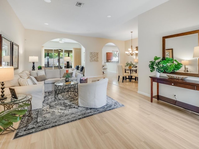 living room with a notable chandelier and light wood-type flooring