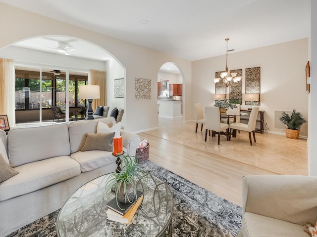 living room with hardwood / wood-style flooring and ceiling fan with notable chandelier