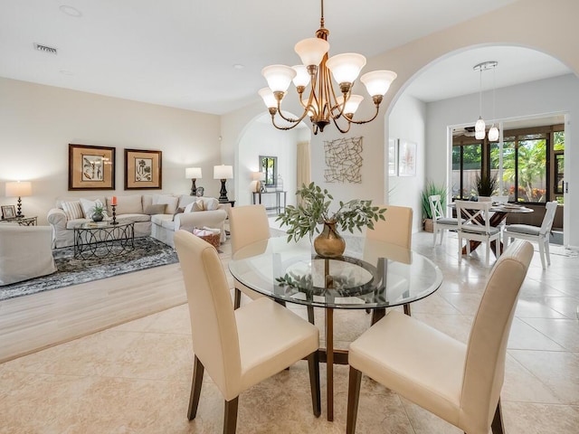 dining space featuring light tile patterned flooring and a chandelier