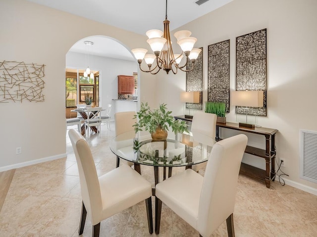 dining area with light tile patterned flooring and a chandelier