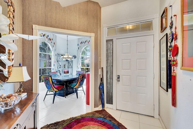 foyer entrance featuring light tile patterned floors and an inviting chandelier