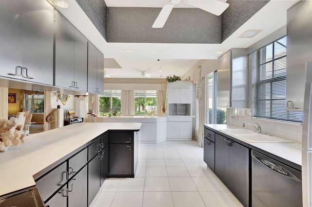 kitchen with sink, light tile patterned floors, ceiling fan, black dishwasher, and decorative backsplash