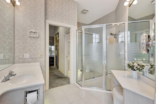 bathroom featuring toilet, vaulted ceiling, vanity, a shower with door, and tile patterned flooring