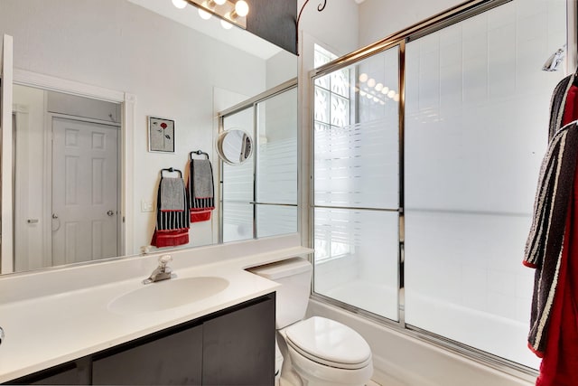 full bathroom featuring toilet, vanity, and shower / bath combination with glass door